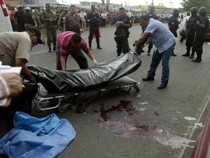 Forenses trasladan los cuerpos de dos policías asesinados en Culiacán