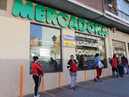 Varias personas esperan para poder entrar a comprar en un supermercado Mercadona de Madrid en plena crisis sanitaria por coronavirus.