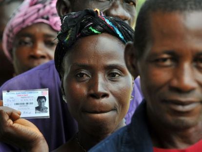 Una mujer sostiene su carn&eacute; para votar en Liberia.