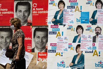 Una mujer pasa ante los carteles electorales de los candidatos del PSdeG, Gonzalo Caballero, y del BNG, Ana Ponton  a la presidencia de la Xunta de Galicia.