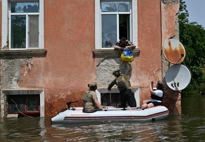 Militares de la Guardia Nacional de Ucrania entregan alimentos a los residentes de un área inundada en la región de Jersón, este jueves.