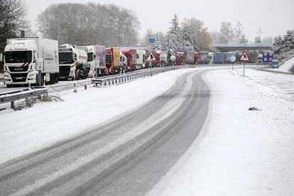 Respecto a la cota de nieve, la AEMET señala que se situará entre 800 y 1.200 metros en el cuadrante noroeste y Sistema Ibérico, 900-1.400 en Pirineos y 1.000-1.200 m en el sureste. En la imagen, decenas de camiones han quedado atascados en la autovía A-15, a la altura de Lecumberri.
