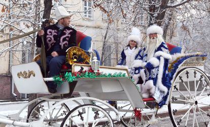 Un home i una dona vestits com Morozko, l'equivalent eslau de Santa Claus, i la seva filla participen en les celebracions d'Any Nou a Bishkek, Kirguizistan.