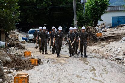 Soldados surcoreanos llegan para limpiar los escombros generados por las fuertes lluvias en Cheongju, este el lunes 17 de julio. 
