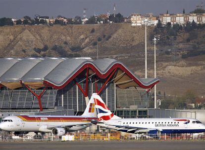 Un avión de Iberia y otro de British Airways, en la T-4 del aeropuerto de Barajas (Madrid).