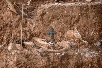 Un crucifijo junto a uno de los restos pertenecientes a los miembros de la Columna Minera que fueron arrojados a la fosa de Pico Reja, tras ser fusilados en agosto del 36. Los objetos suelen ser uno de los elementos clave para poder identificar a las víctimas.