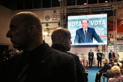 En la pantalla, Silvio Berlusconi durante un acto electoral.