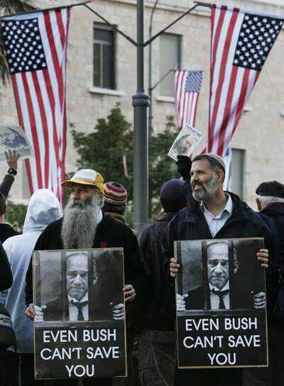 Manifestantes en Jerusalén, la víspera de la llegada de Bush. En las pancartas, se ve la foto del primer ministro israelí, Ehud Olmert, entre rejas. Debajo se lee: 