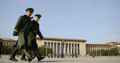 Dos polic&iacute;as paramilitares atraviesan la plaza pequinesa de Tiananmen para ir al Gran Palacio del Pueblo. 