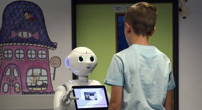 Un niño habla con el robot Pepper.
