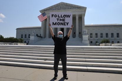 Un manifestante frente al Tribunal Supremo con un cartel en referencia al caso de las finanzas de Donald Trump, este miércoles.