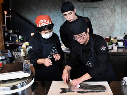 Dos alumnos de los cursos de cocina japonesa de Gakko Japo, en Madrid, con su profesora Sonomi Tsuchiya.