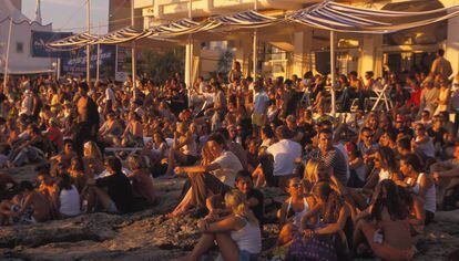 Turistas en Café del Mar en la Bahía de San Antonio de Ibiza, esperando la puesta del Sol.