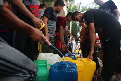 Palestinos llenaban bidones de plástico con agua en Rafah, en el sur de la franja de Gaza, en medio del ataque israelí.