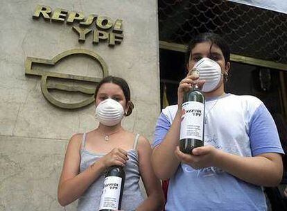 Activistas muestran botellas de agua contaminada en la sede de Repsol en Buenos Aires.