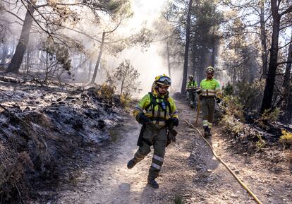 Miembros de las brigadas forestales de bomberos refrescan los alrededores de Montán (Castellón) este miércoles.