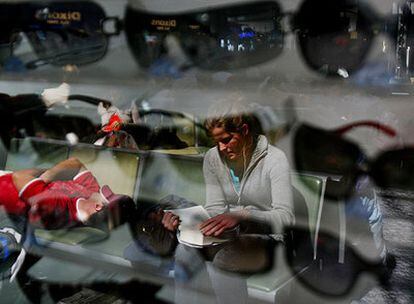 Una mujer frente a una tienda de gafas en el aeropuerto de Londres-Heathrow.
