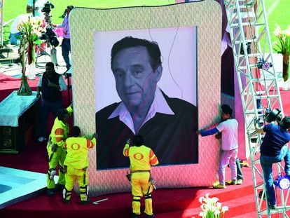 Trabajadores manipulan un retrato de Chespirito, en un tributo en honor del actor tras su muerte.