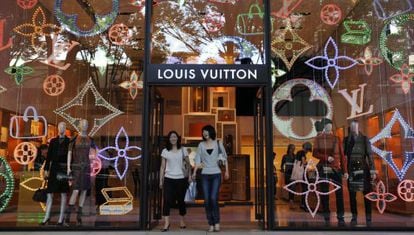 Dos clientas salen de la tienda que la firma Louis Vuitton