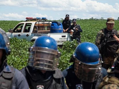 Agentes de la Policía Nacional resguardan una plantación de soja el 22 de enero de 2014 en la colonia de Crescencio González en el distrito de General Resquín, en el departamento de San Pedro (Paraguay) durante una protesta de campesinos contra el uso de agrotóxicos.
