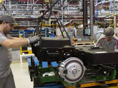 Dos operarios colocan las baterías de la furgoneta eléctrica Citroën Berlingo en la planta de PSA en Vigo.