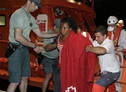 Miembros de la Guardia Civil y Cruz Roja atienden a una inmigrante en el puerto de Motril.