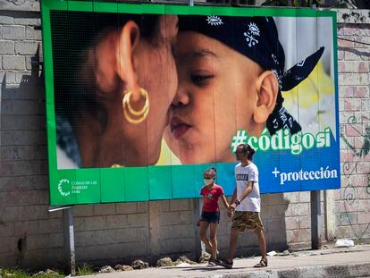 AME9508. LA HABANA (CUBA), 24/09/2022.- Un hombre y su hija pasan caminando frente a una valla que hace parte de la campaña por el SÍ en el referendo sobre el código de familia, hoy en La Habana (CUBA). Más de ocho millones de cubanos están convocados el domingo a participar en el referendo sobre el paquete legislativo que abre la posibilidad a la aprobación del matrimonio gay, la adopción por parte de parejas homosexuales y el embarazo "solidario", entre otros temas. EFE/Yander Zamora
