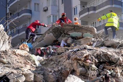 Miembros de emergencias buscan supervivientes entre los escombros de un edificio en la localidad de Adana (Turquía).
