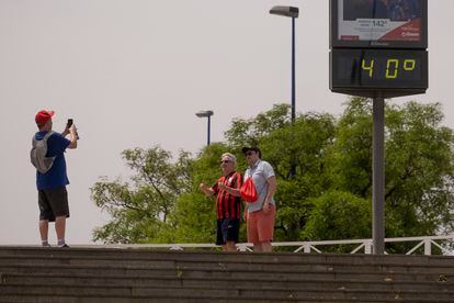 Dos turistas se hacían una foto el jueves junto a un termómetro que marcaba 40 grados en Sevilla, a primera hora de la tarde.