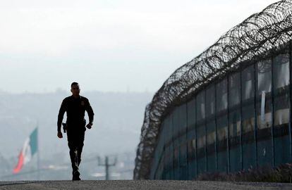 Un agente de la policía de fronteras, junto a la valla en San Diego. 