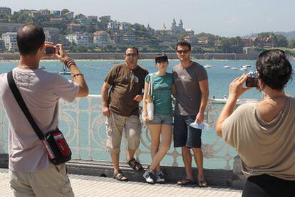 Un grupo de personas se fotografía ante la playa de la Concha en San Sebastián.