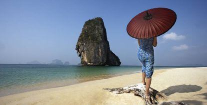 Una mujer pasea por la playa de Phang Na (Tailandia).