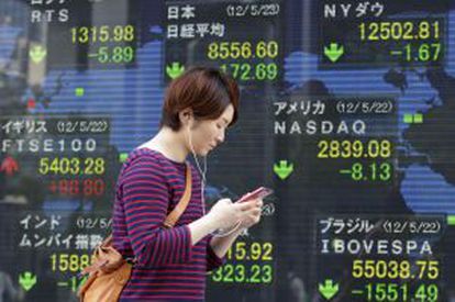 Una mujer pasa ante los luminosos de la Bolsa de Tokio.