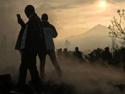 Un vecino usa su teléfono móvil para tomar fotografías de las casas destruidas por la lava, que aún siguen humeantes, cerca de Goma (República del Congo), este domingo.