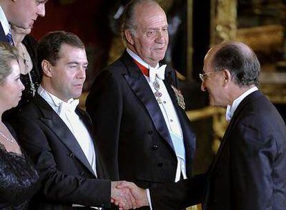 El presidente de Repsol, Antonio Brufau, saluda al presidente ruso, Dmitri Medvédev, en presencia del Rey momentos antes de la cena de gala  en el Palacio Real.