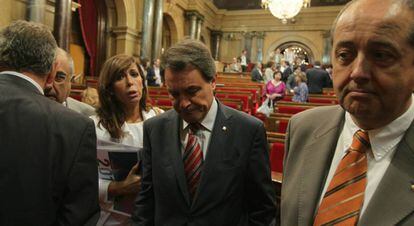 Artur Mas (c), entre Alicia Sánchez-Camacho (PP) y el consejero de Interior, Felip Puig, en el Parlamento catalán, mientras cientos de indignados se manifestaban en el exterior.