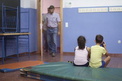 Dos niños de una familia desalojada ayer de la aldea La Alcornocosa, durante su estancia en las instalaciones del colegio Peñaluenga de El Castillo de las Guardas.