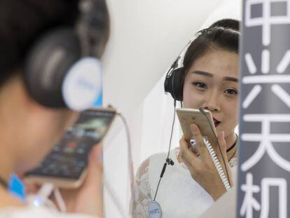 Una azafata de ZTE en el Mobile World Congress de Shanghái hace una demostración de la calidad de grabación de sonido del Axon 7 cantando una canción en una cabina