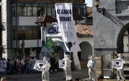 Instante en el que cinco hombres con la cara cubierta, abren pancartas pidiendo el acercamiento de reclusos de ETA durante las fiestas de Leitza ( Navarra) .