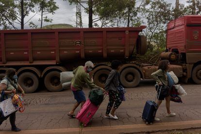 Algunos miembros de la caravana arrastran su equipaje sobre la carretera que une a Río de Janeiro con Brasilia, luego de tener que abandonar su autobús por una falla mecánica.