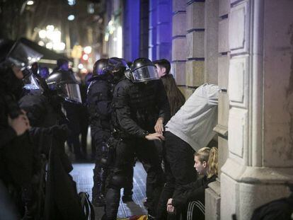 Los Mossos d'Esquadra registran a algunos de los manifestantes.