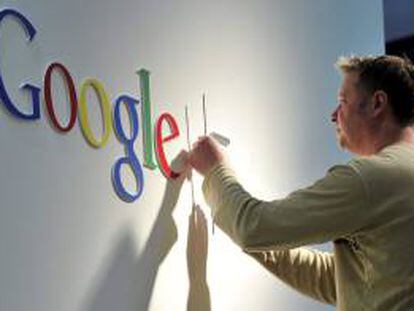 Un hombre da los últimos retoques al logo de Google. EFE/Archivo