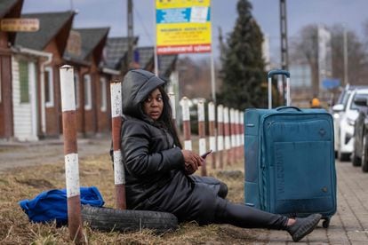 Una mujer africana huida del conflicto en Ucrania descansa en la frontera de Medyka, entre este país y Polonia, el 27 de febrero de 2022.