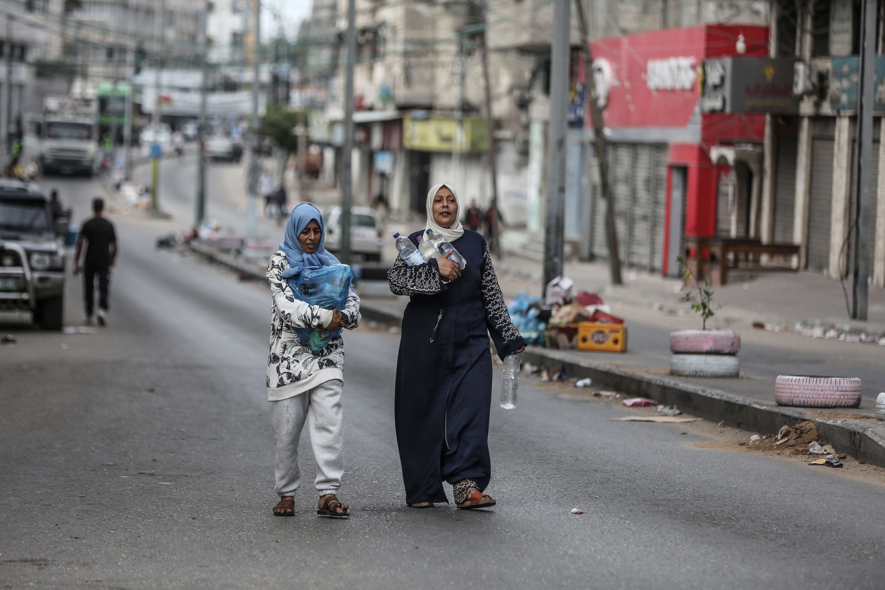 Dos mujeres palestinas acarrean botellas de agua en Ciudad de Gaza, este martes. 