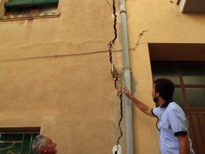 Unos vecinos de Barberà de la Conca observan la grieta de su casa.