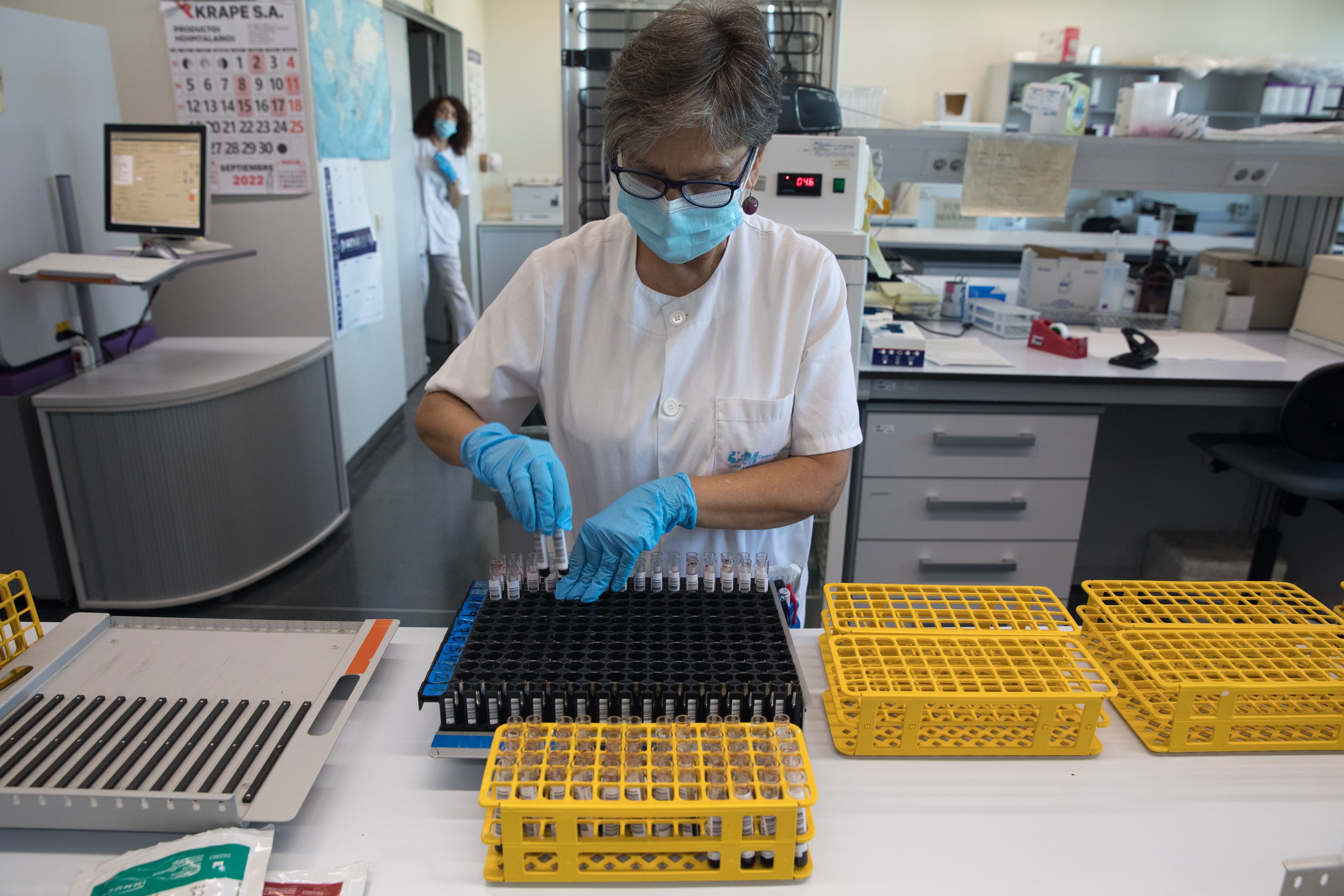 Una empleada del centro coloca los tubos con las muestras para meterlos en una máquina que compruebe el grupo sanguíneo.