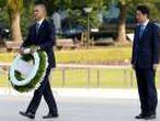 U.S. President Obama carries a wreath as Japanese PM Abe looks on, in front of a cenotaph at Hiroshima Peace Memorial Park in Hiroshima