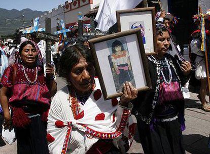 Familiares de los asesinados en la matanza de Acteal muestran fotos de las víctimas durante una marcha en San Cristóbal, Chiapas