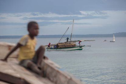 Varias personas transportan madera en una embarcación frente a la costa de Paquitequete, en Mozambique.