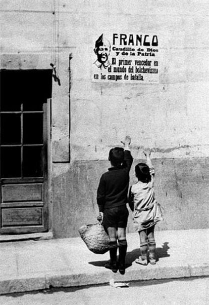 Dos niños saludan brazo en alto ante un cartel de Franco en septiembre de 1939.